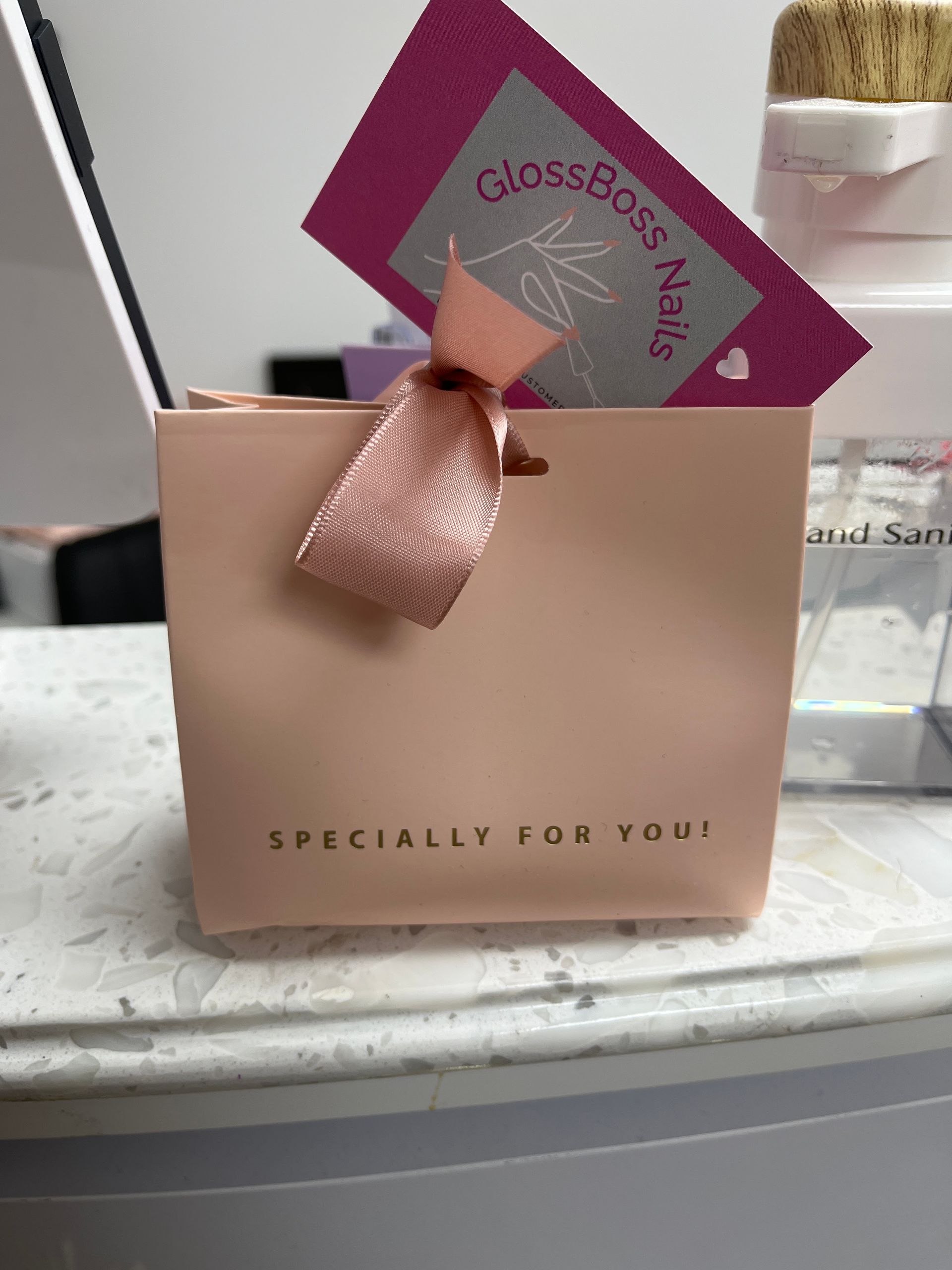 Pink gift bag with a tag and ribbon on a countertop, labeled “Especially for You.”
