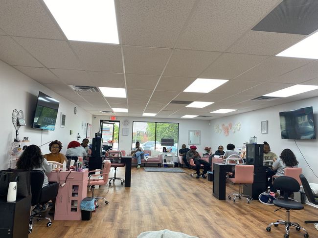 Hair salon with clients getting services at styling stations and mirrors along both walls