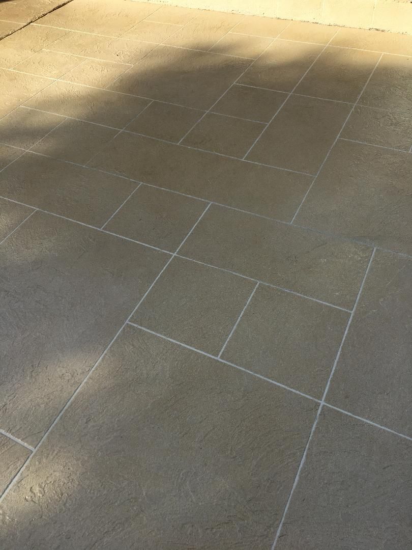 Sunlit stone pavement with faint chalk line markings in a courtyard