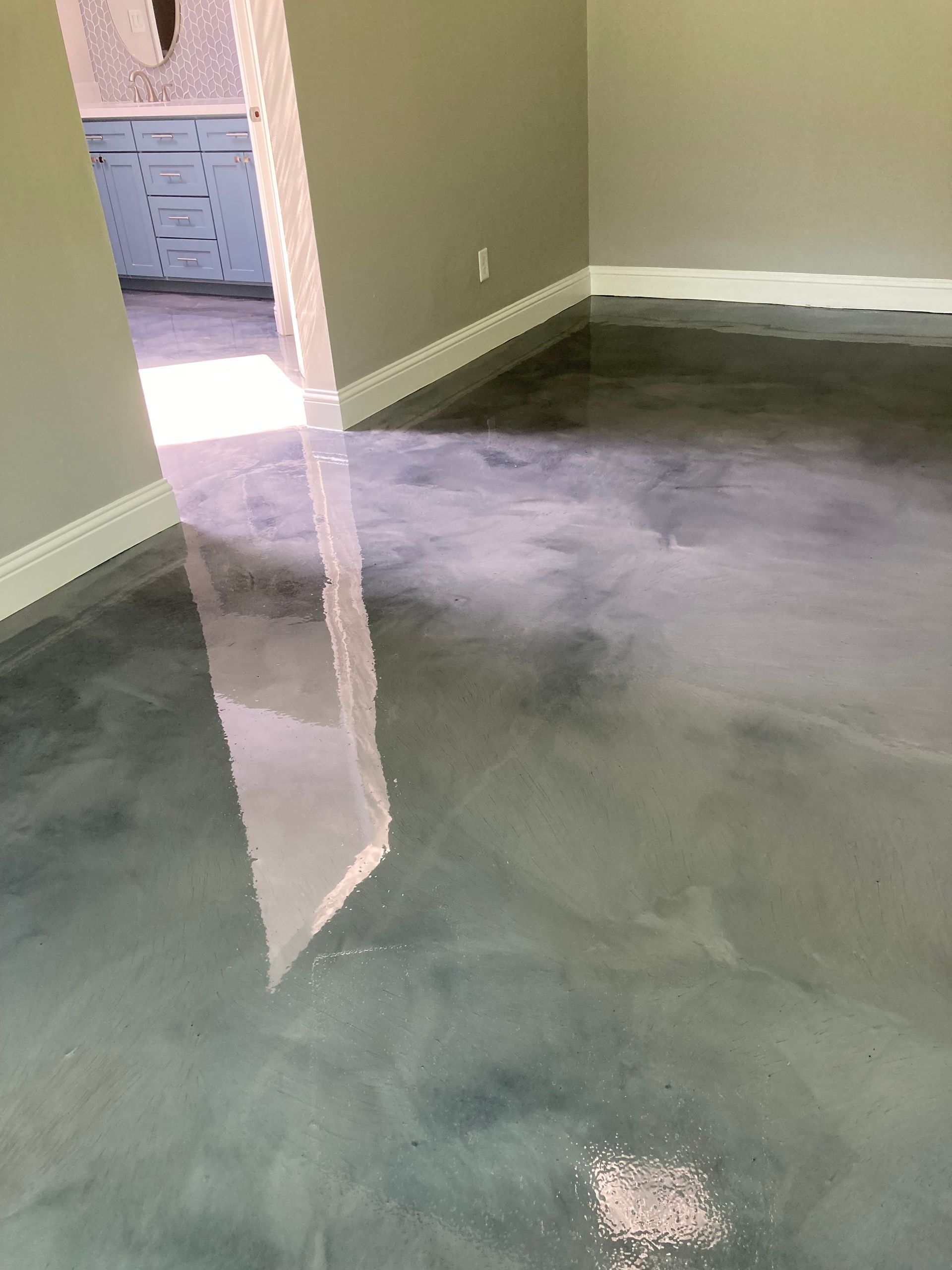 Empty room with gray carpet, beige walls, and an open door leading to a hallway.