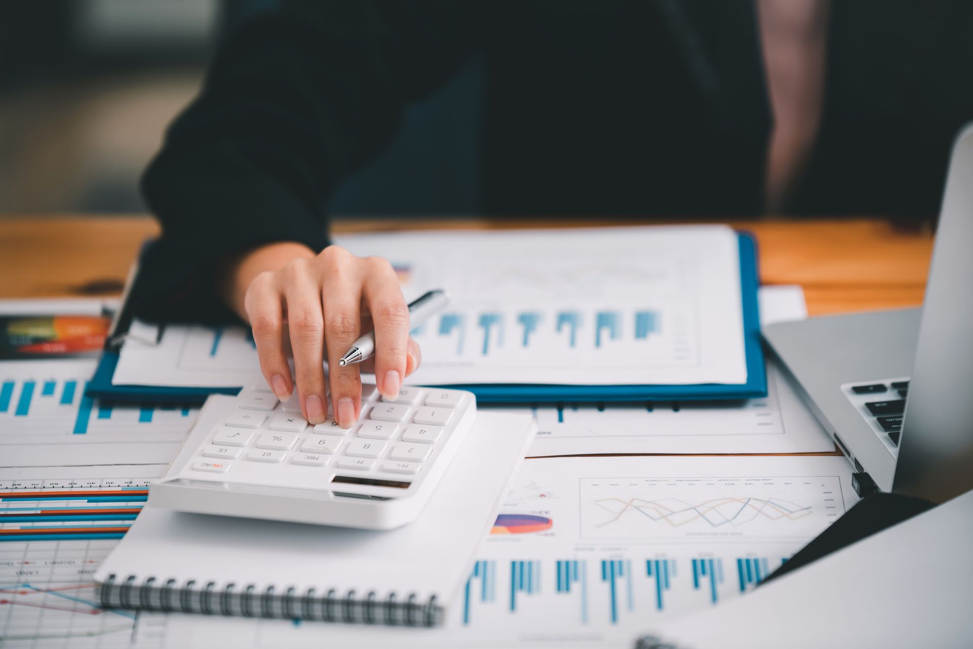 Accountant in Columbia, SC using a calculator and laptop to manage finances.