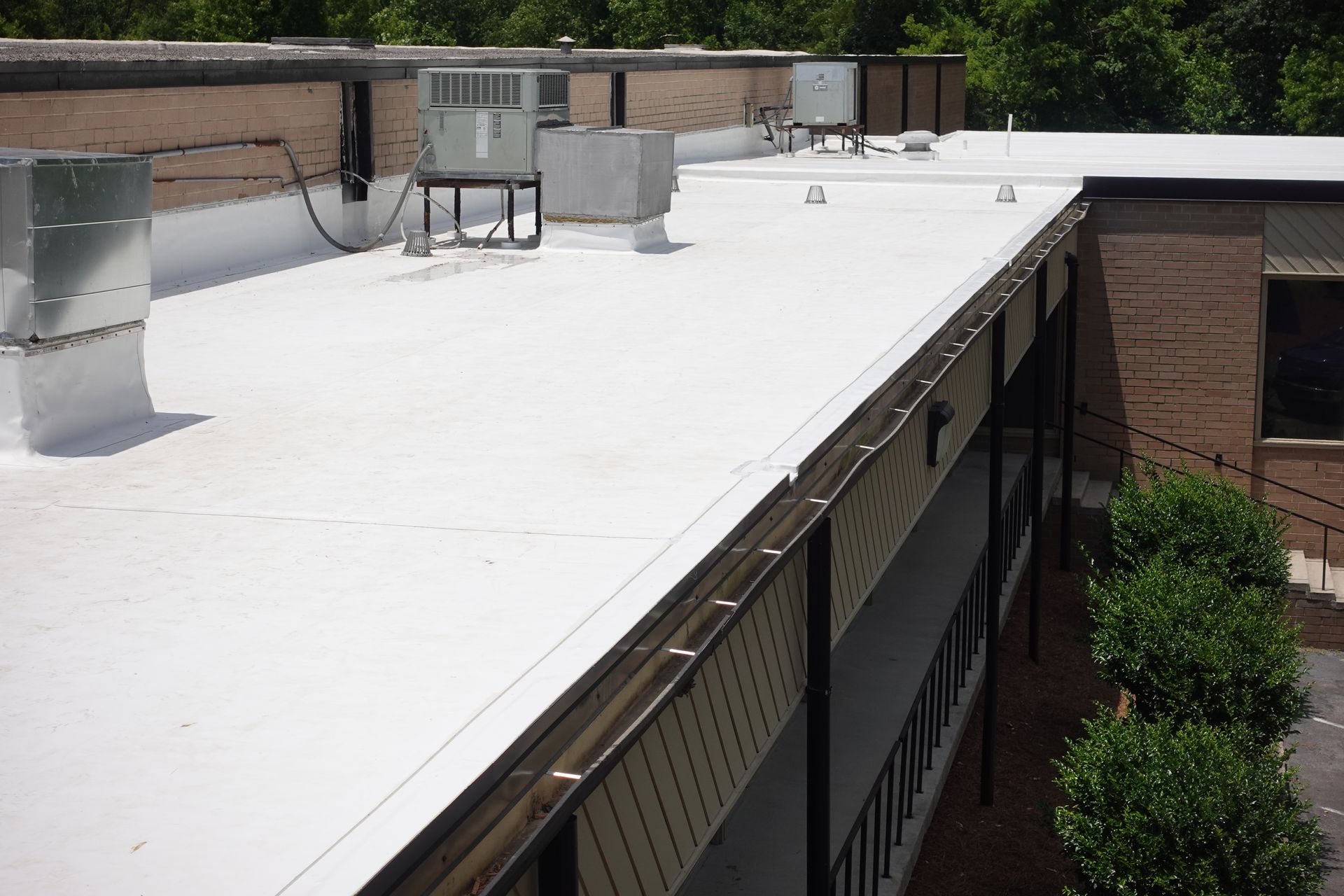 Finished Carlisle 60-mil white TPO roofing system at Boss Design in High Point, NC, featuring rooftop HVAC units and completed membrane detailing.