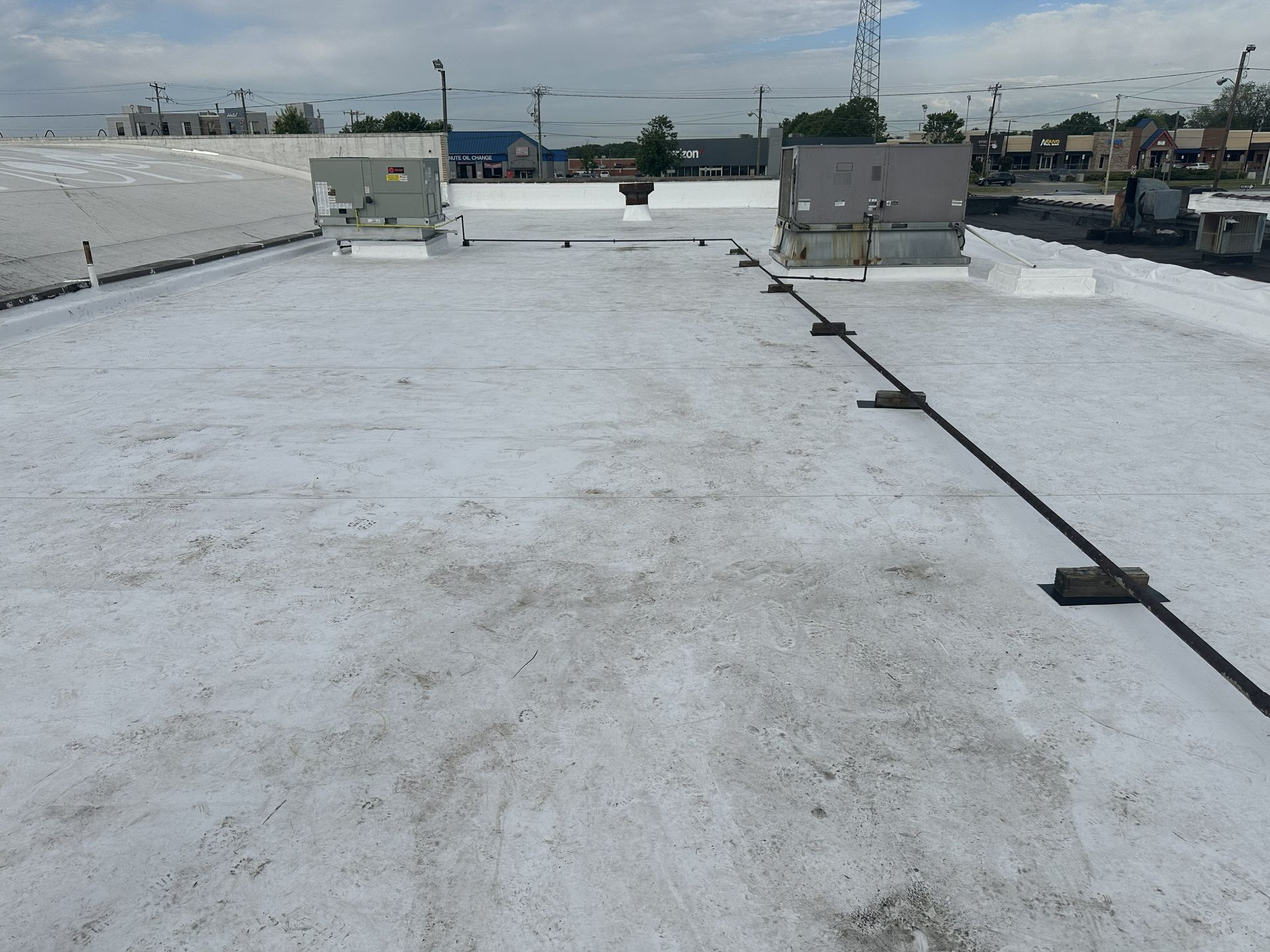 Completed Carlisle 60-mil white TPO commercial roof recover by B&D Roofing Solutions at Franklin Properties on Lawndale Drive in Greensboro, NC, showing rooftop HVAC units and flashing details.