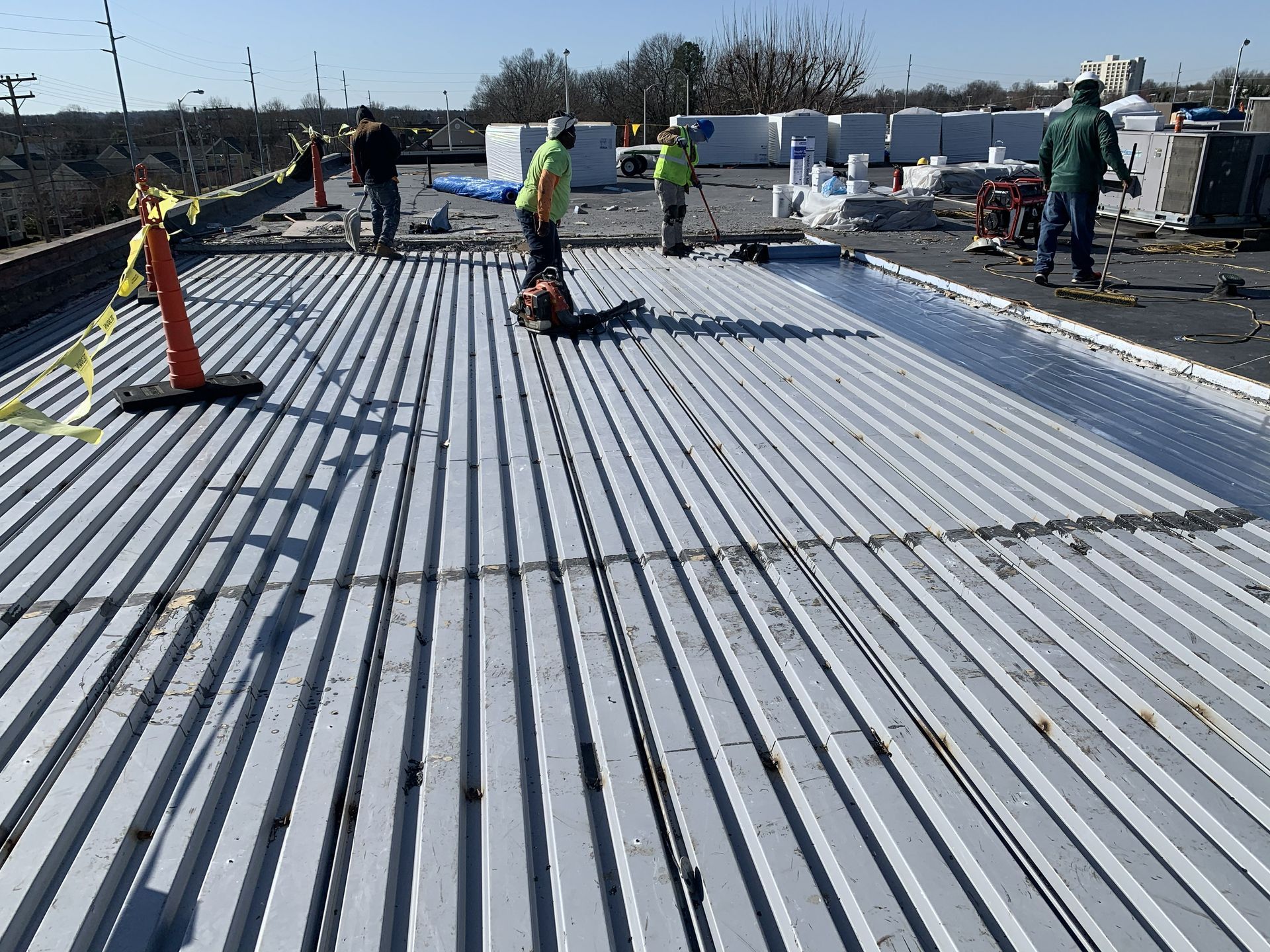 B&D Roofing Solutions crew working on exposed steel roof decking during the commercial EPDM roof replacement at the High Point Housing Authority main office in High Point, NC.