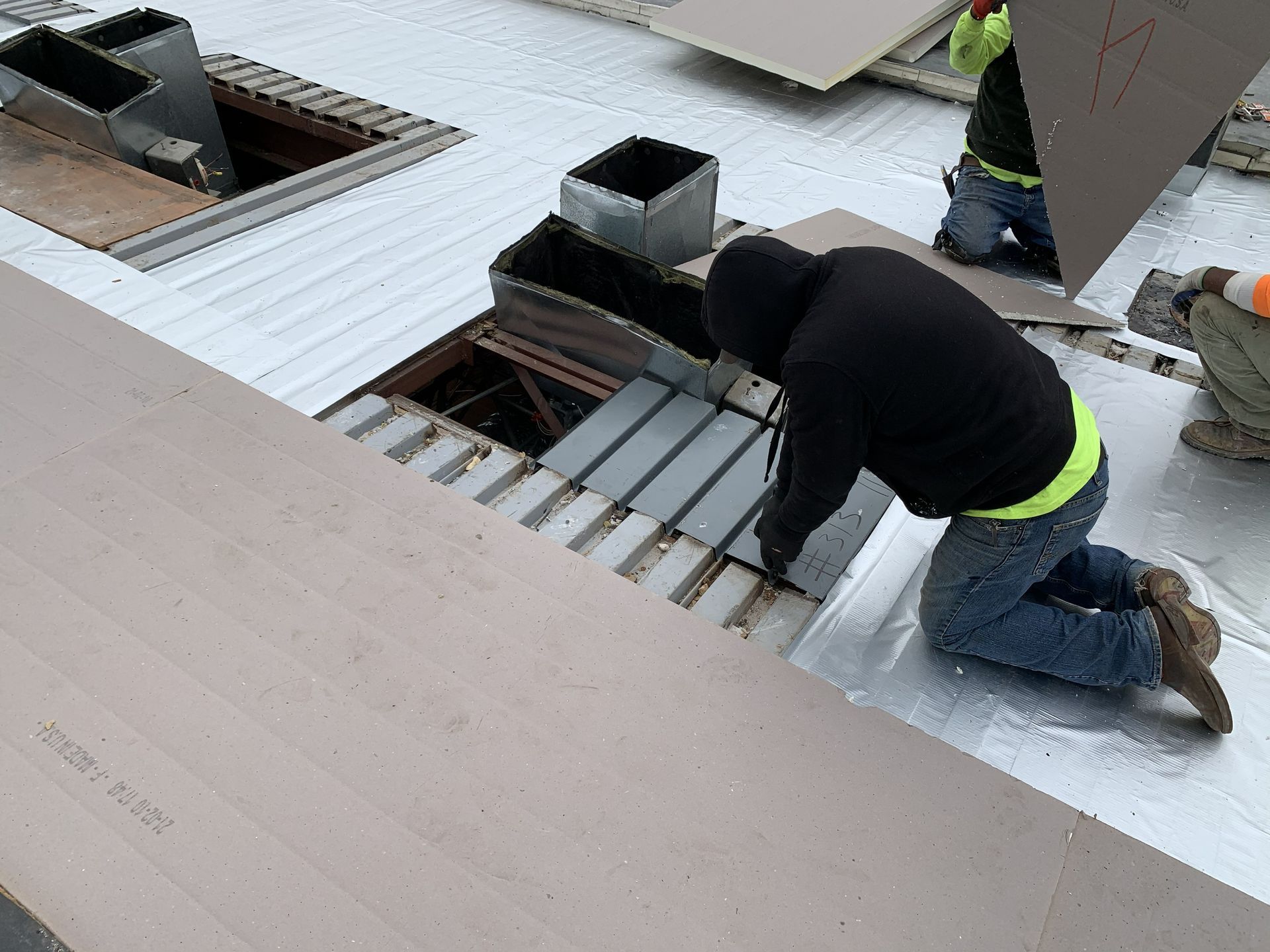 B&D Roofing Solutions crew replacing steel roof decking around a rooftop equipment curb during the High Point Housing Authority commercial roof replacement in High Point, NC.