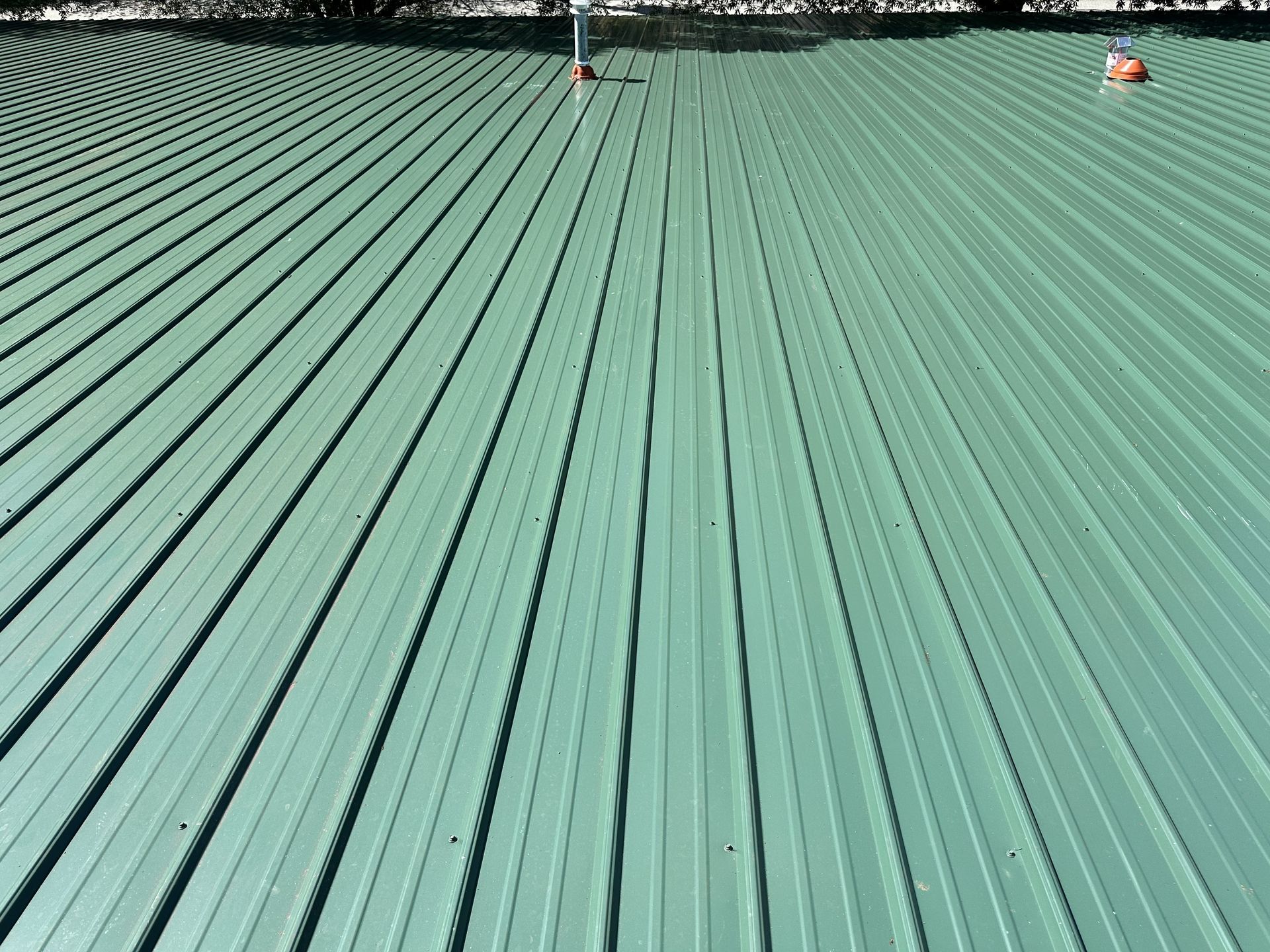 Close-up of newly installed green commercial metal roof panels at Peters Development in High Point, NC.