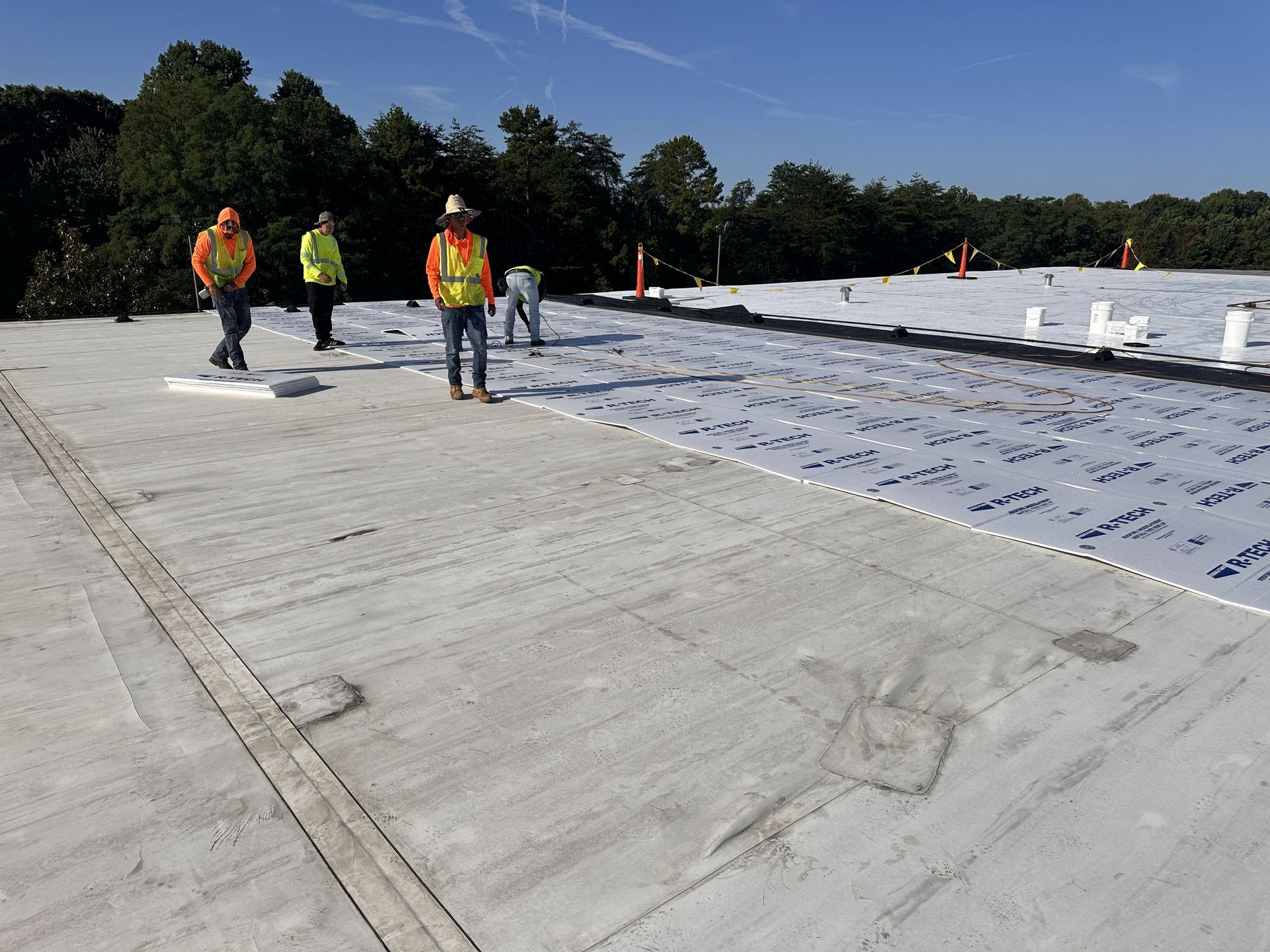 B&D Roofing Solutions crew installing roof insulation boards during Phase II of the commercial TPO roof recover at IMMI SafeGuard Seating in High Point, NC.