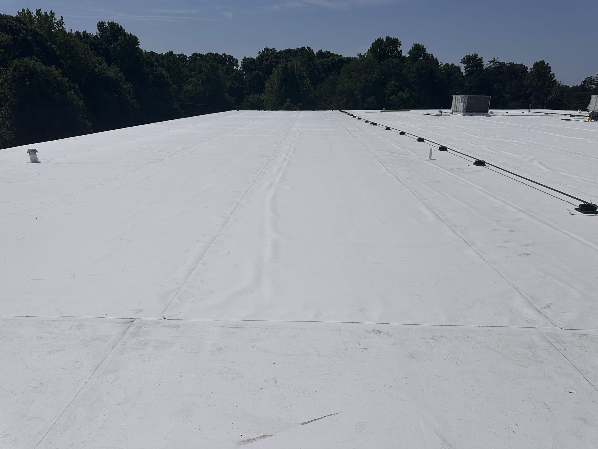 Completed 60-mil white TPO roofing system during Phase II of the commercial roof recover at IMMI SafeGuard Seating in High Point, NC, installed by B&D Roofing Solutions.