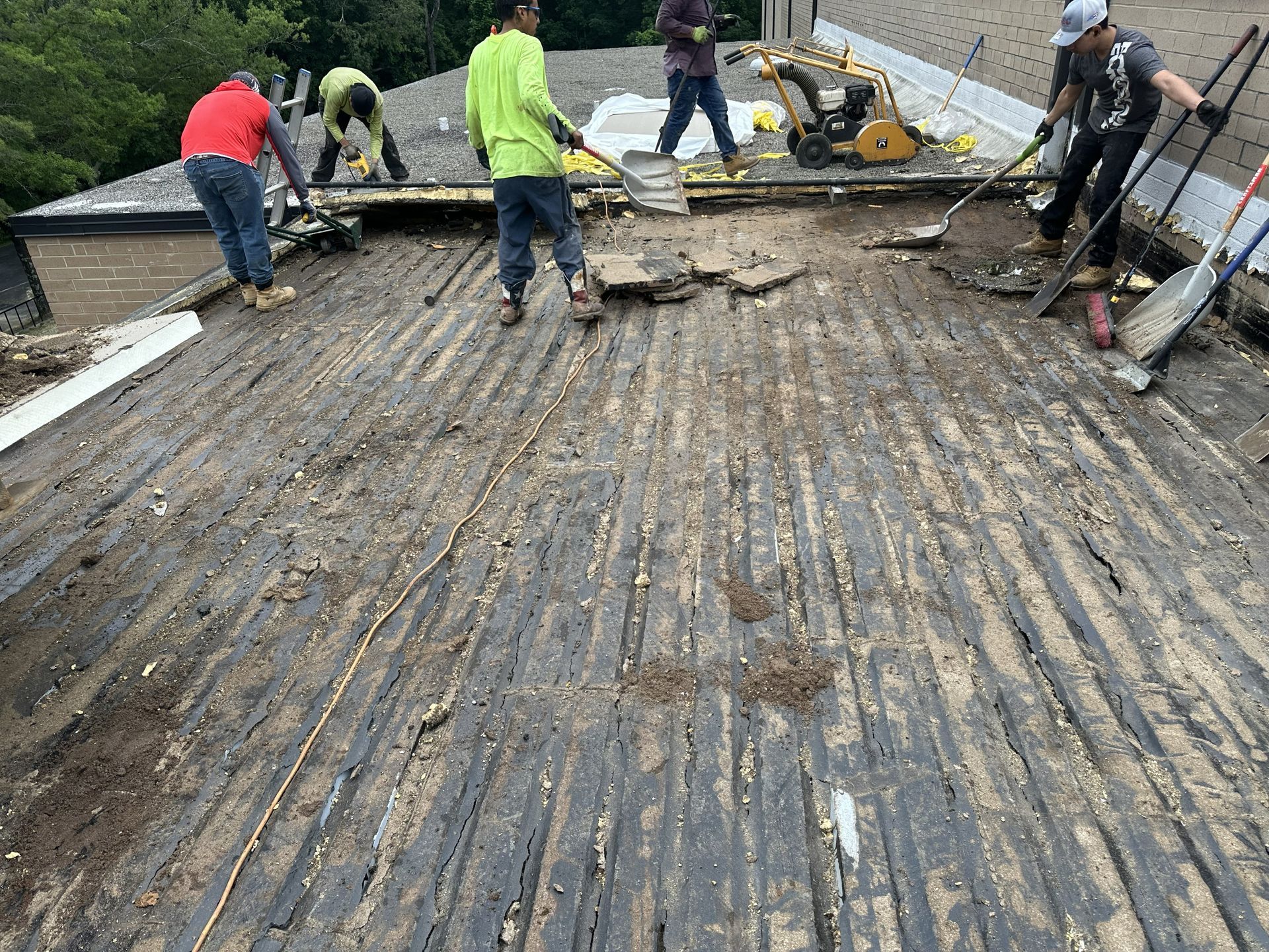 Existing commercial roofing materials being removed to expose the steel roof decking during the Boss Design roof replacement in High Point, NC, by B&D Roofing Solutions.