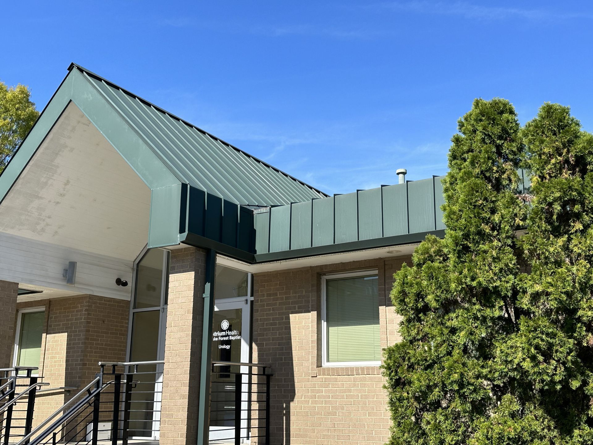 Existing green metal roof at Peters Development medical office building in High Point, NC, before replacement.