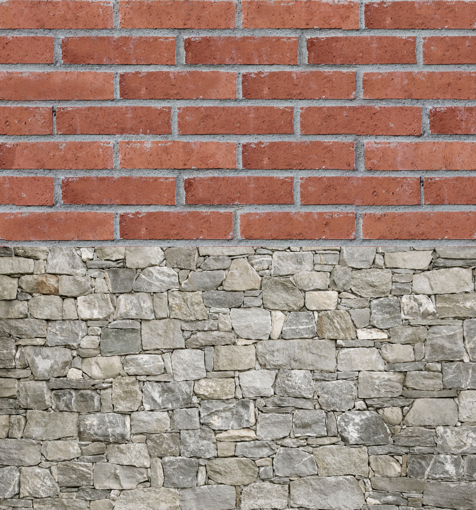 Red brick wall above a rough gray stone wall.