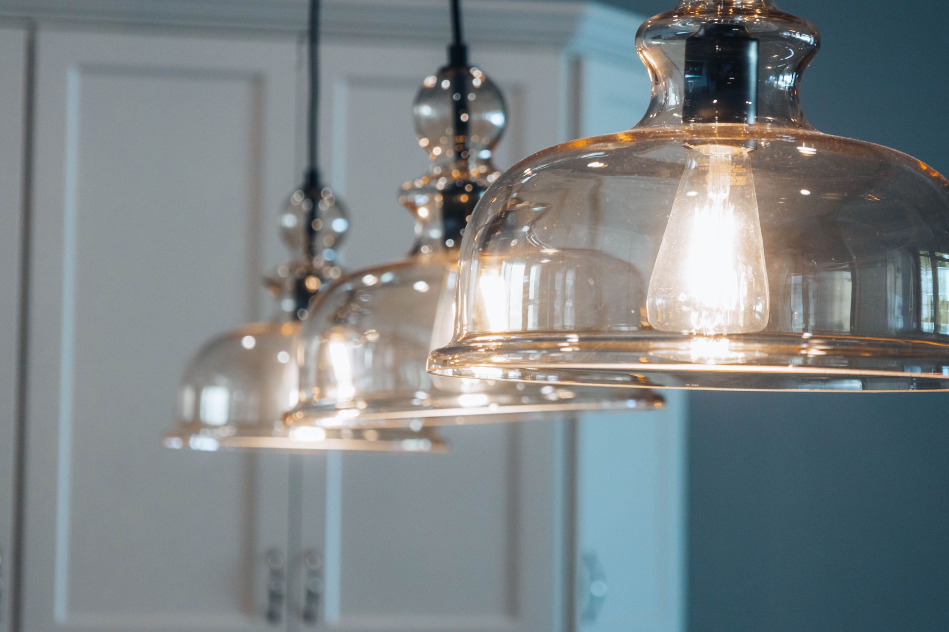 Three shiny pendant lights hanging in a modern kitchen