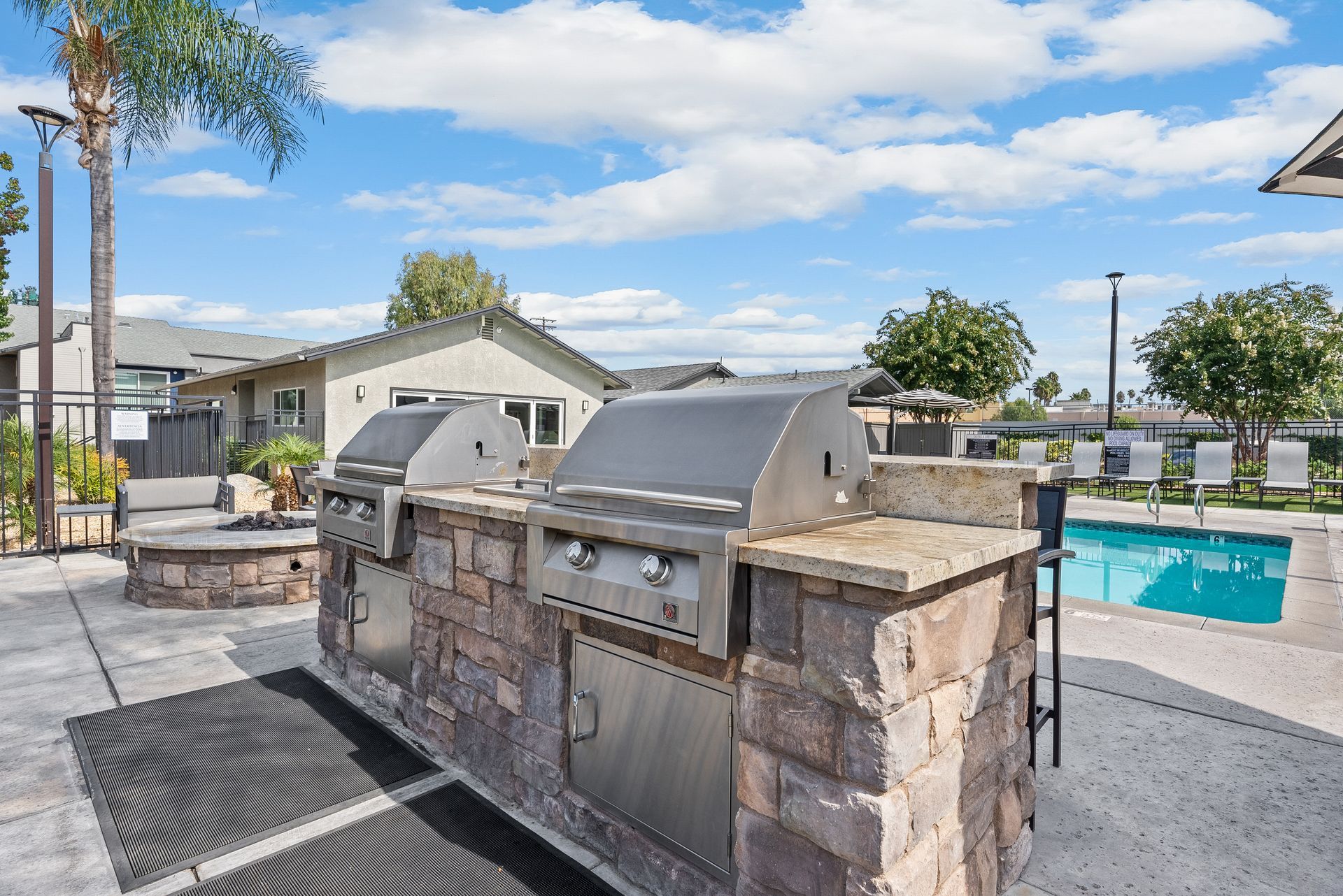 A grill is sitting next to a swimming pool.
