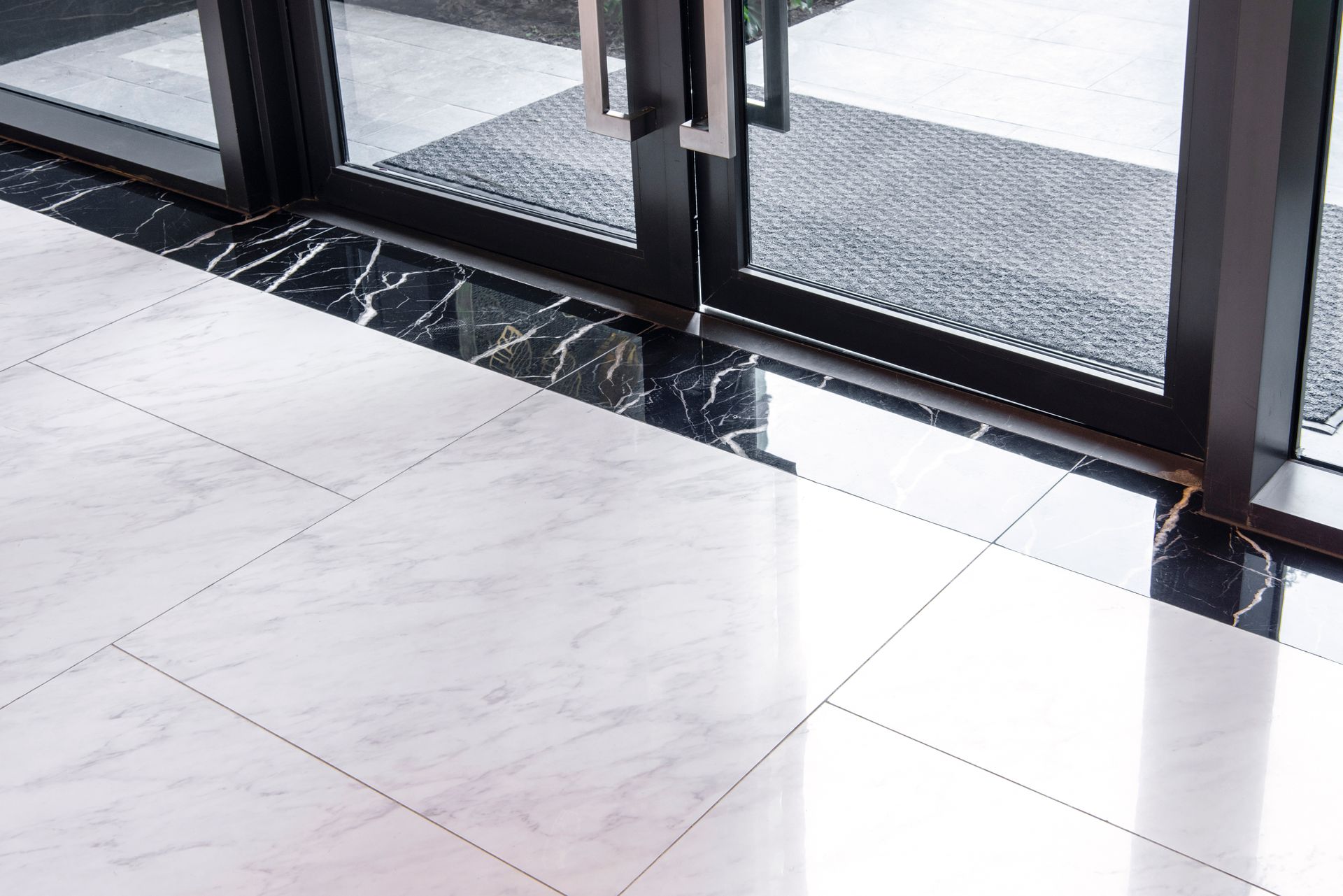 A close up of a tiled floor next to a glass door
