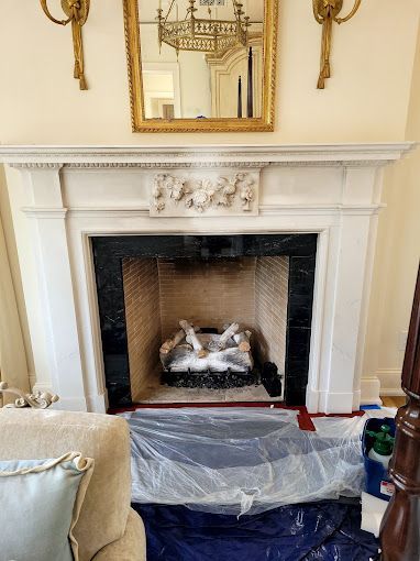 A living room with a fireplace and a mirror.