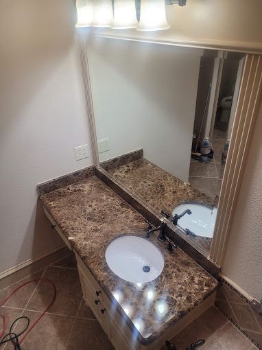 A bathroom with two sinks and a large mirror.