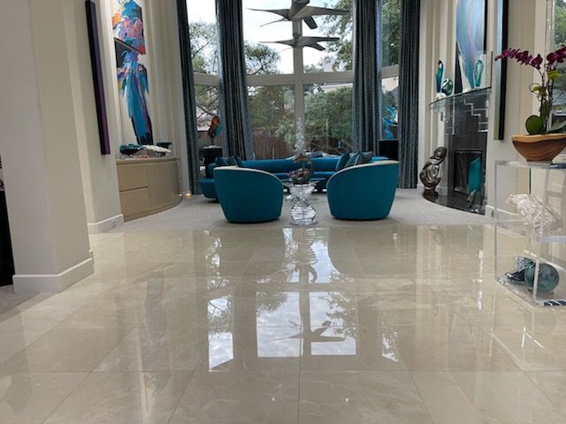 A living room with a marble floor and blue chairs