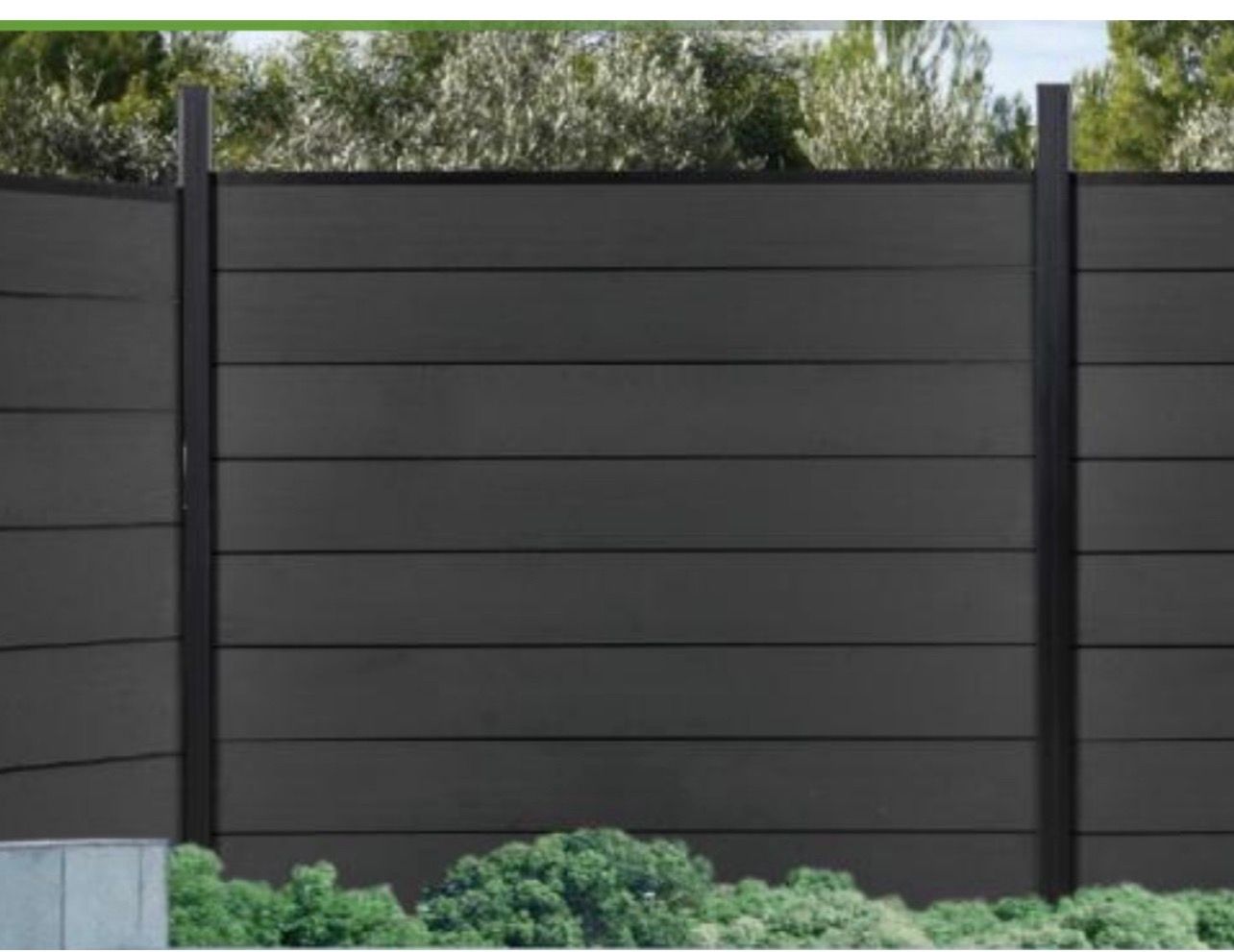 Dark horizontal slat fence with black posts behind green shrubs outdoors