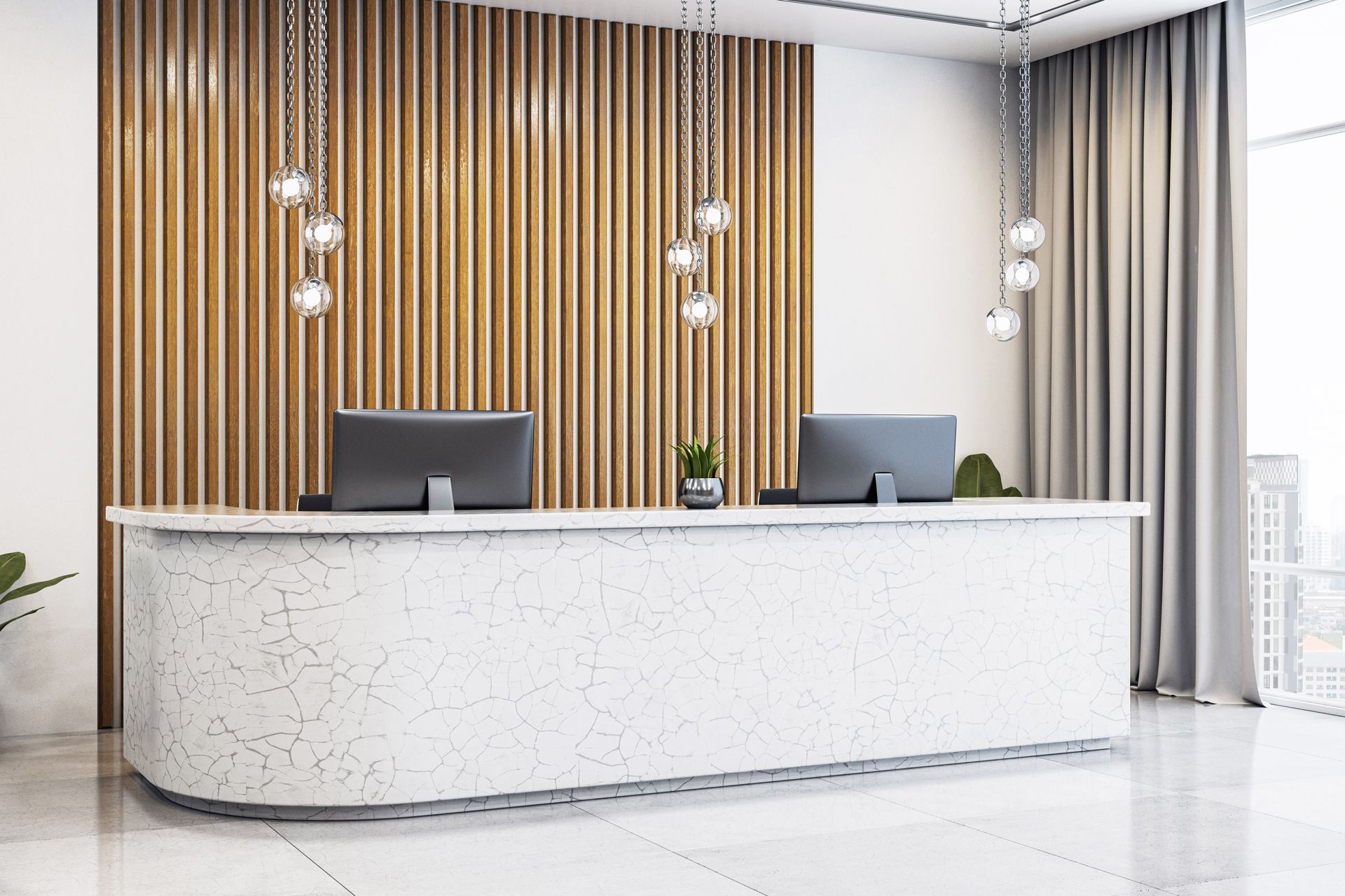 White reception desk with two monitors, wooden paneling, and hanging lights.