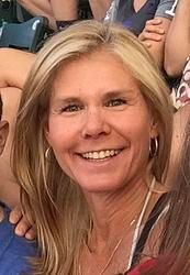 A close up of a woman smiling in a crowd of people.