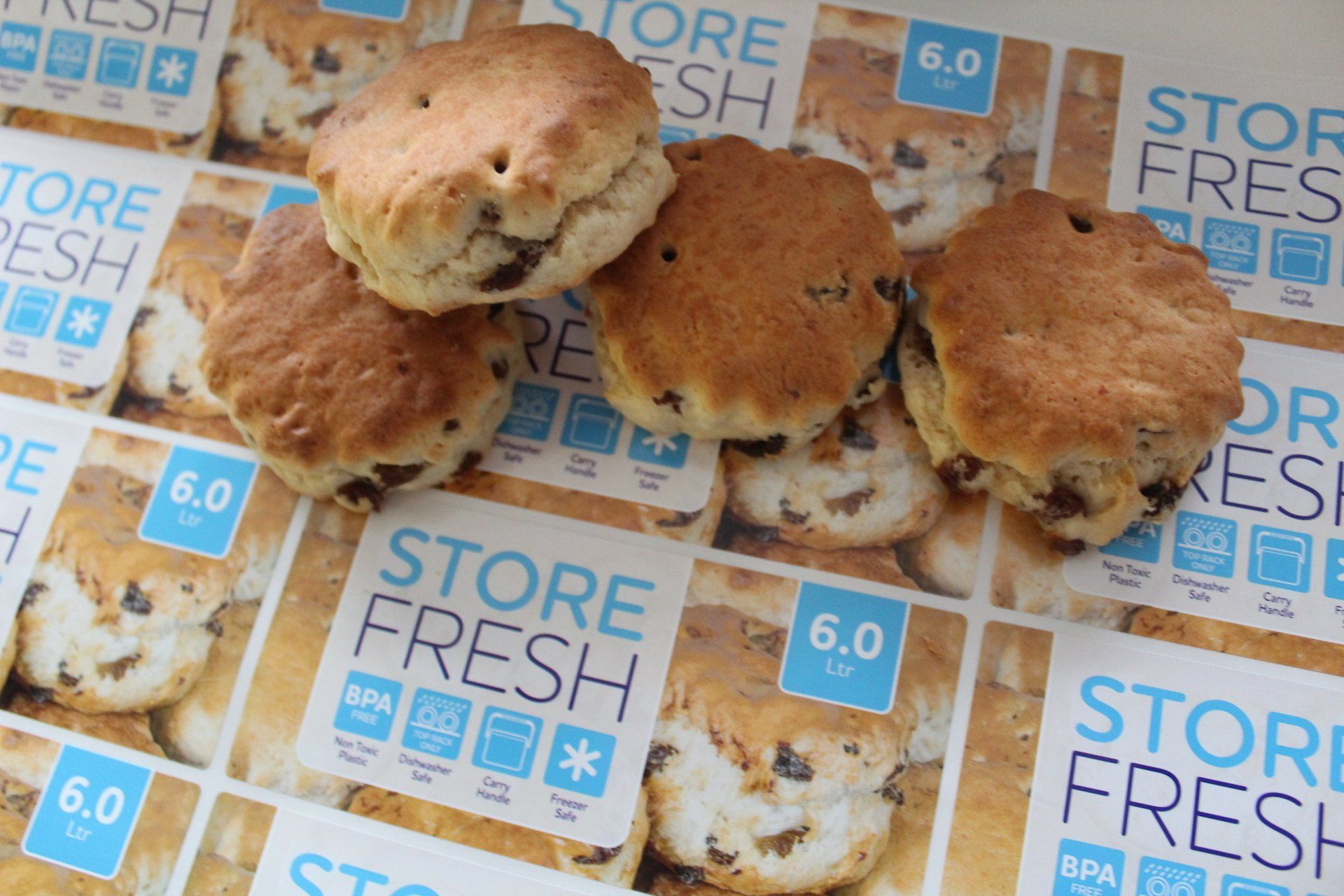 A number of fresh scones laid on top of a sheet of printed scone labels