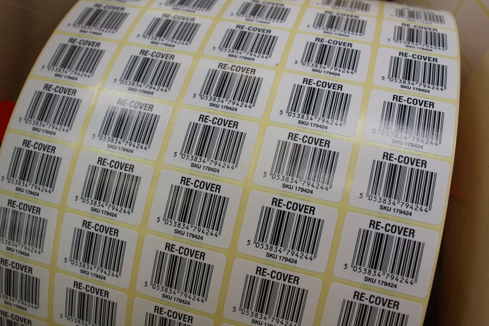 A large reel of barcode labels printed 5 across, ready to be slit down and rewound