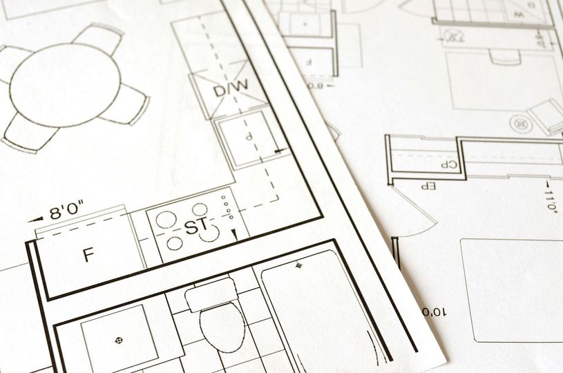 Architectural floor plan sketches with room labels and measurements on white paper