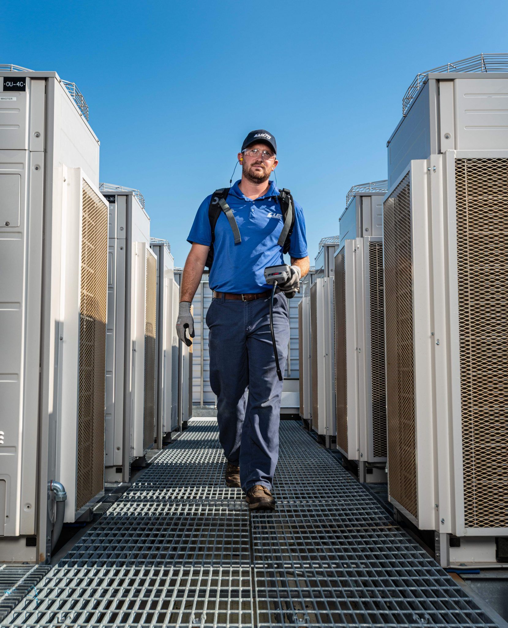 Technician walking between outdoor units - DST Partners