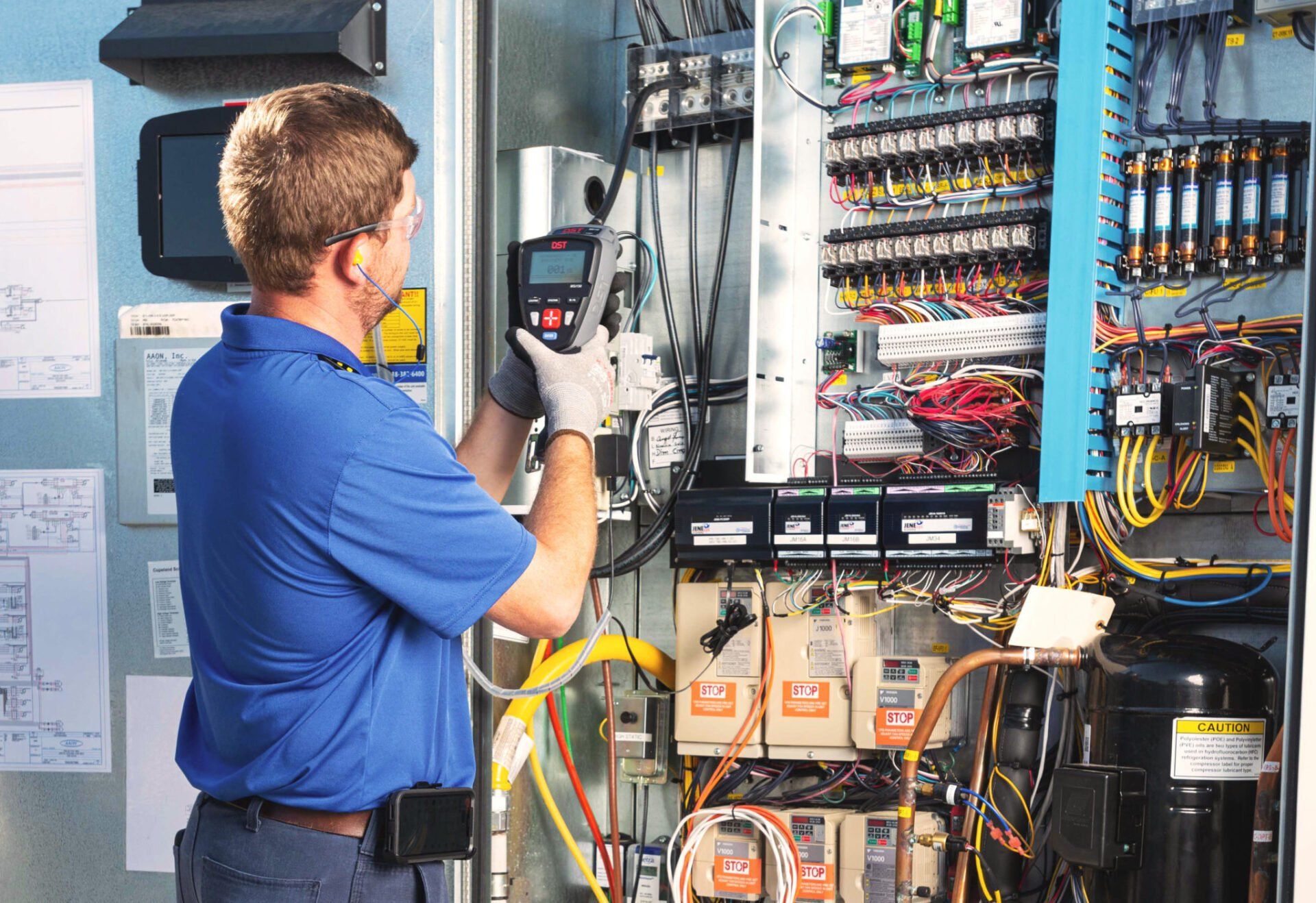 Technician inspecting DST control panel - Lower Total Costs