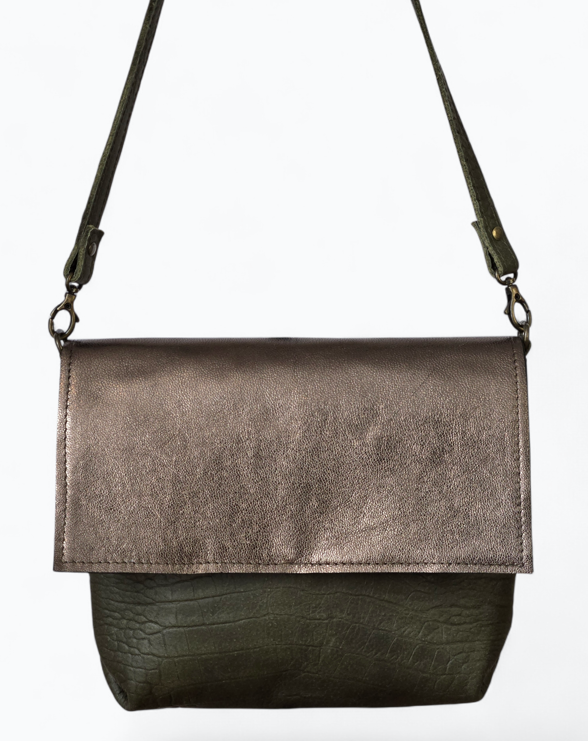 Een donkere, metallic bronzen, rechthoekige crossbodytas met klep en een smalle schouderband op een witte achtergrond.