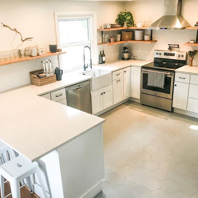 A kitchen with white cabinets , stainless steel appliances , a sink , and a stove.