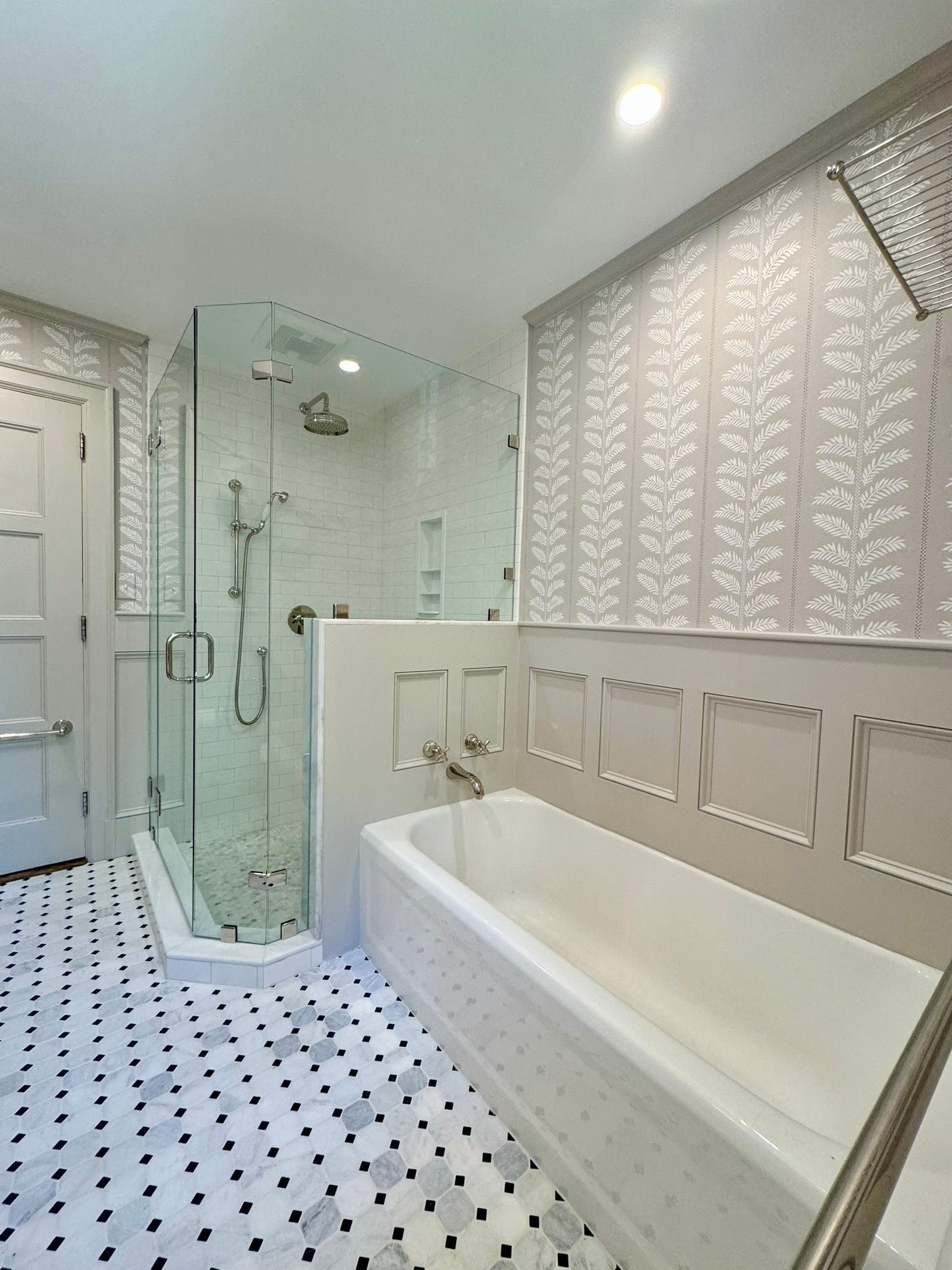 Bright white bathroom with glass shower, white tub, and black-and-white tiled floor