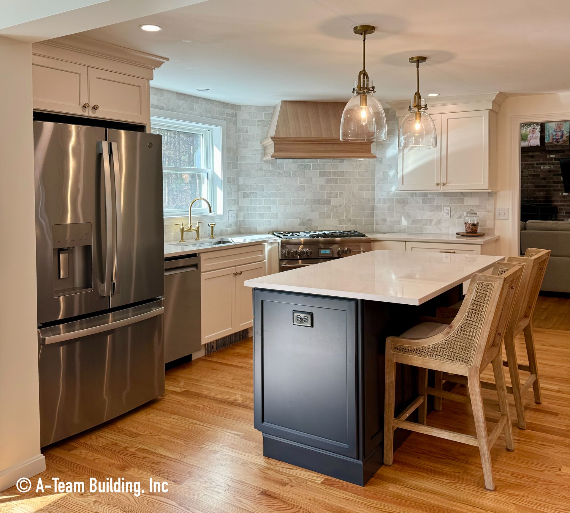Modern kitchen with stainless steel fridge, marble island, white cabinets, and wicker bar stools