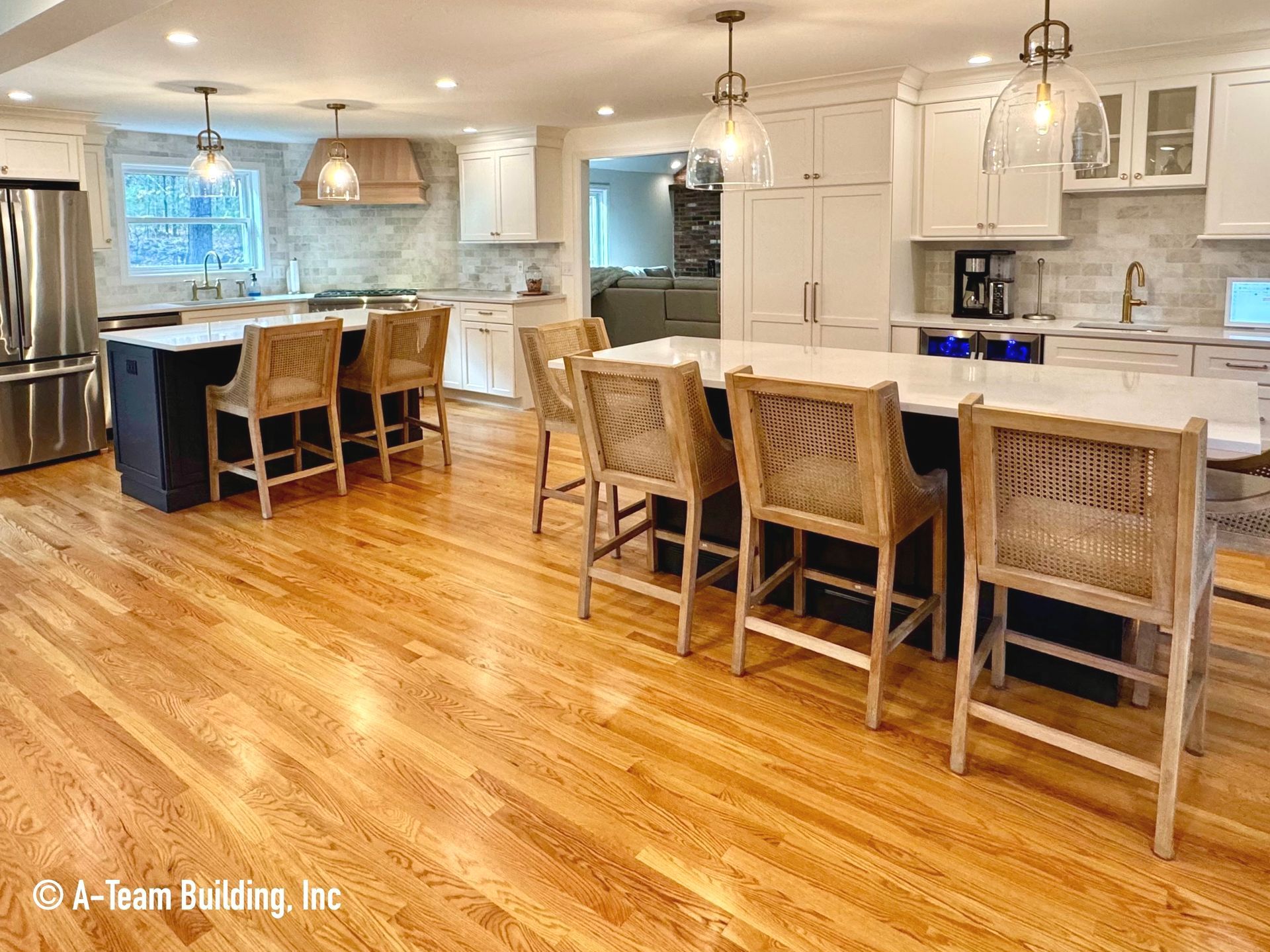 Bright kitchen with white cabinets, hardwood floors, island seating, and blue-accented counters