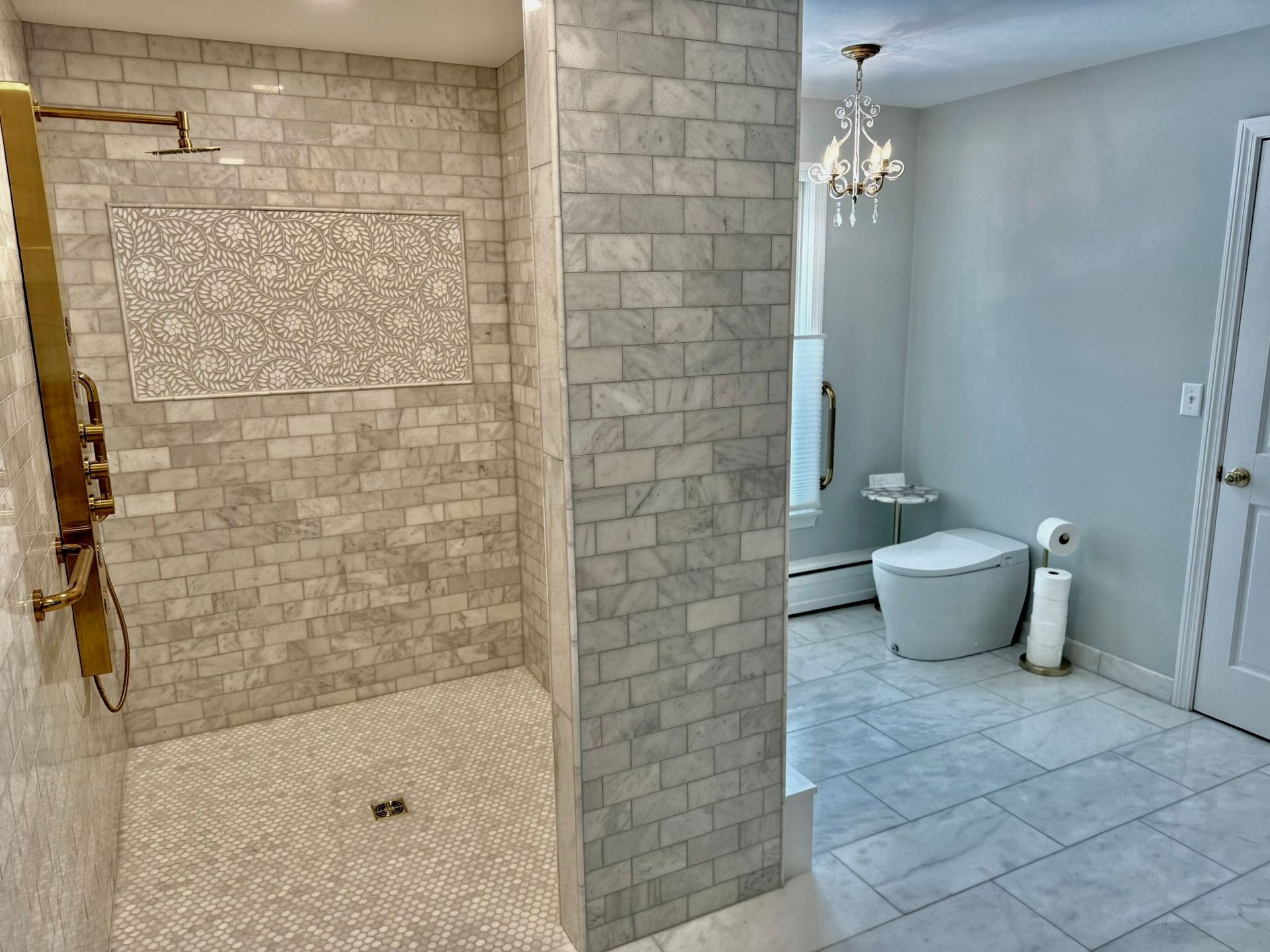 Bathroom with tiled shower on left and separate toilet area on right, in light neutral colors