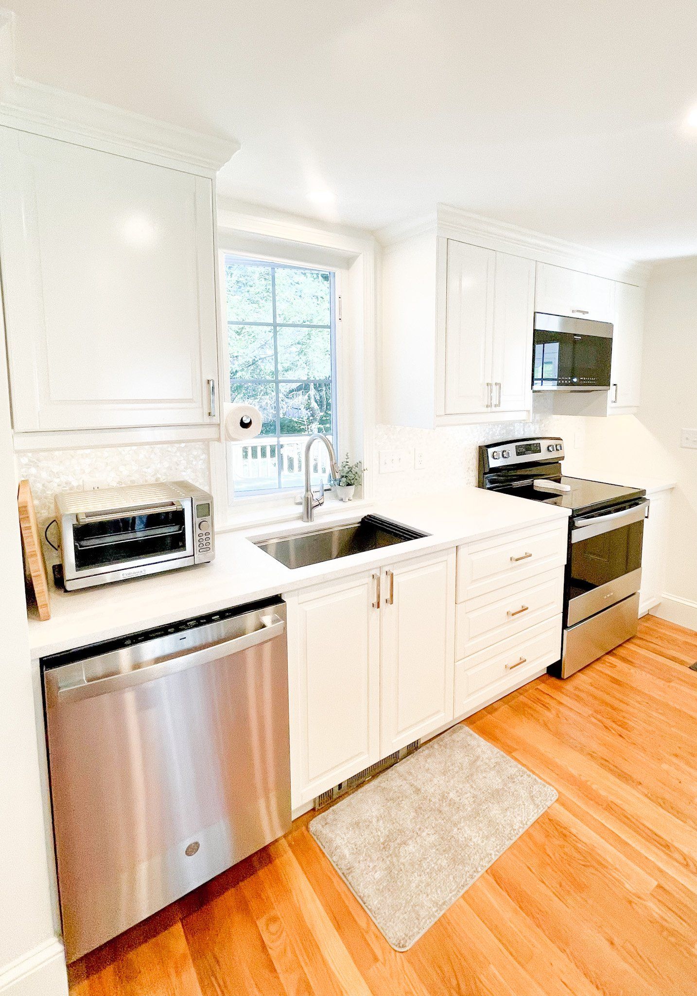 A kitchen with white cabinets and stainless steel appliances