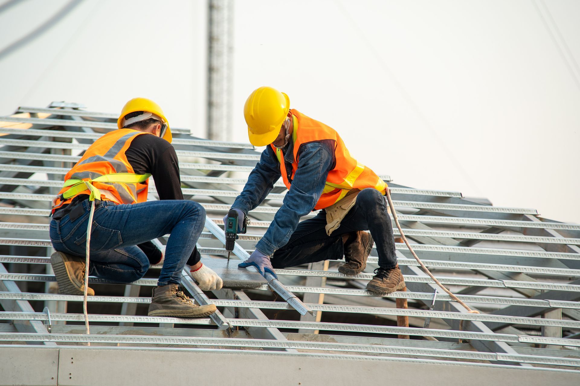 Due operai edili stanno lavorando sul tetto di un edificio.