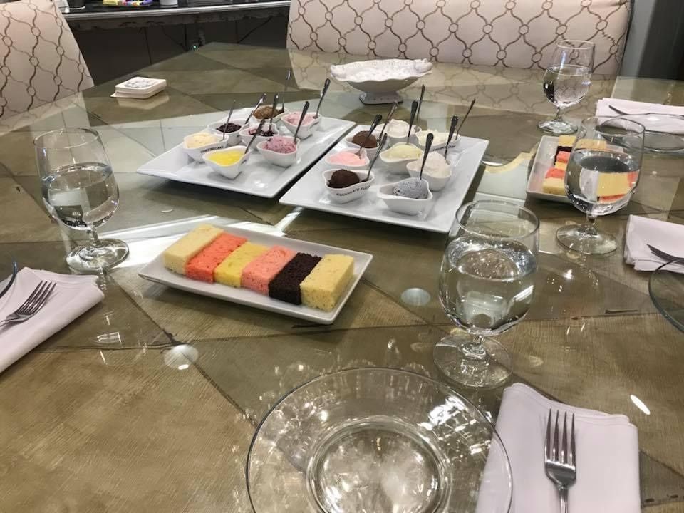 Table set with plates, glasses, and colorful desserts in a restaurant dining setting