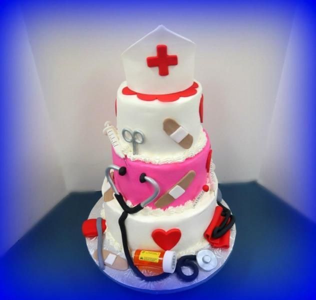 White-and-pink medical-themed cake with red cross and stethoscope on a blue plate