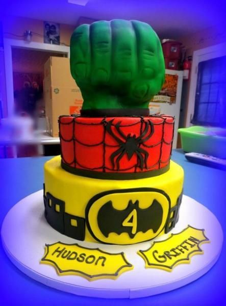 Batman-themed cake with green fist topper, red Spider-Man band, and yellow Bat-Signal base reading “Hudson” and “Griffin”