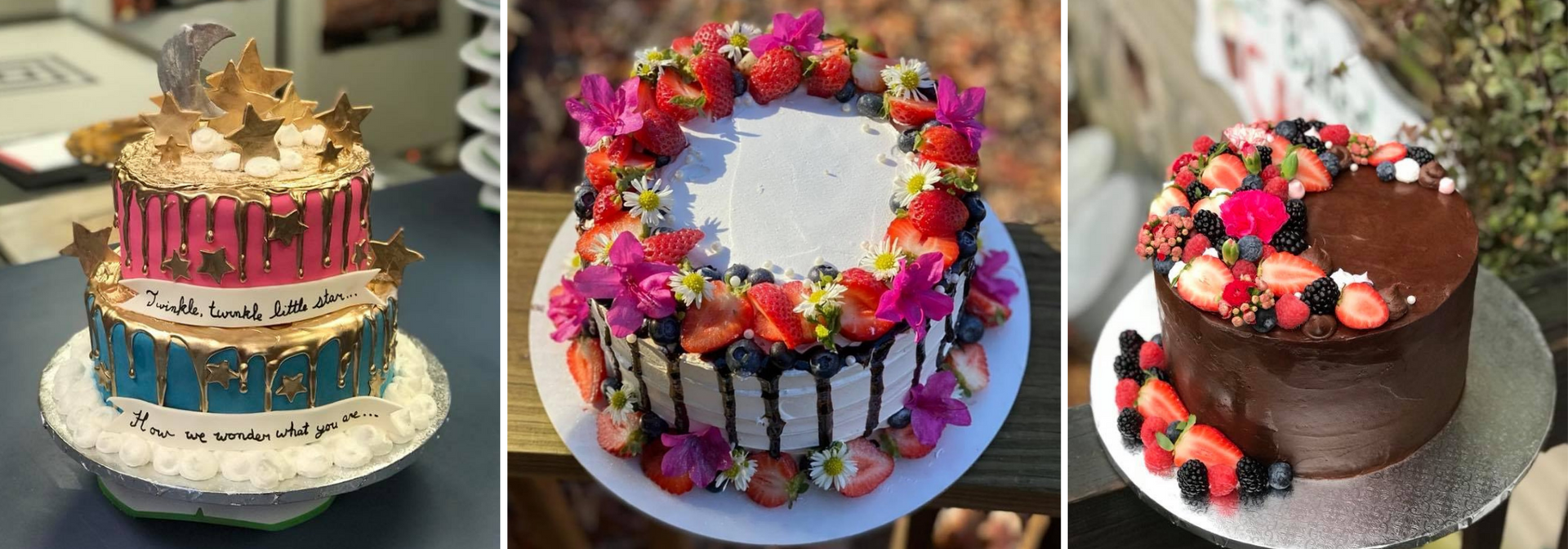 Three decorated cakes with colorful flowers and fruit on display stands