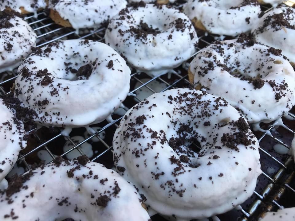 White frosted donuts cooling on a wire rack, topped with chocolate crumbs