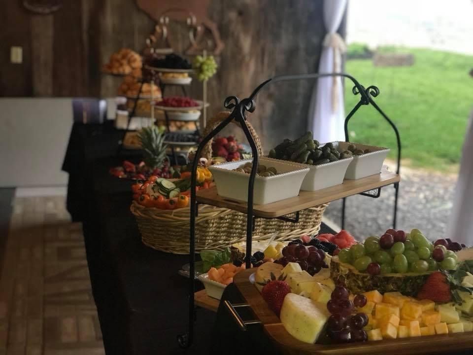 Dessert and fruit display on tiered trays beside a rustic indoor/outdoor table