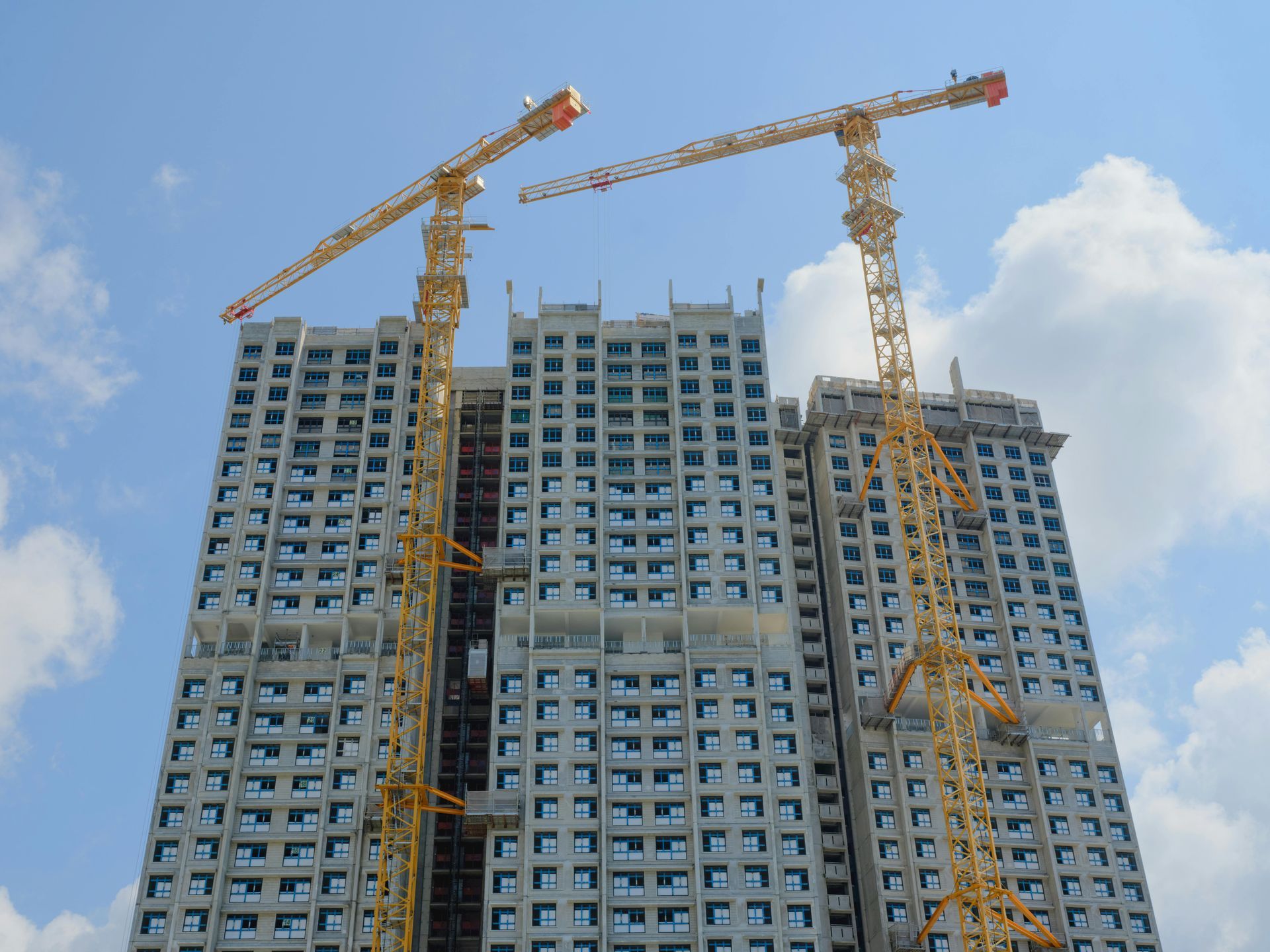 A building under construction with cranes on top of it