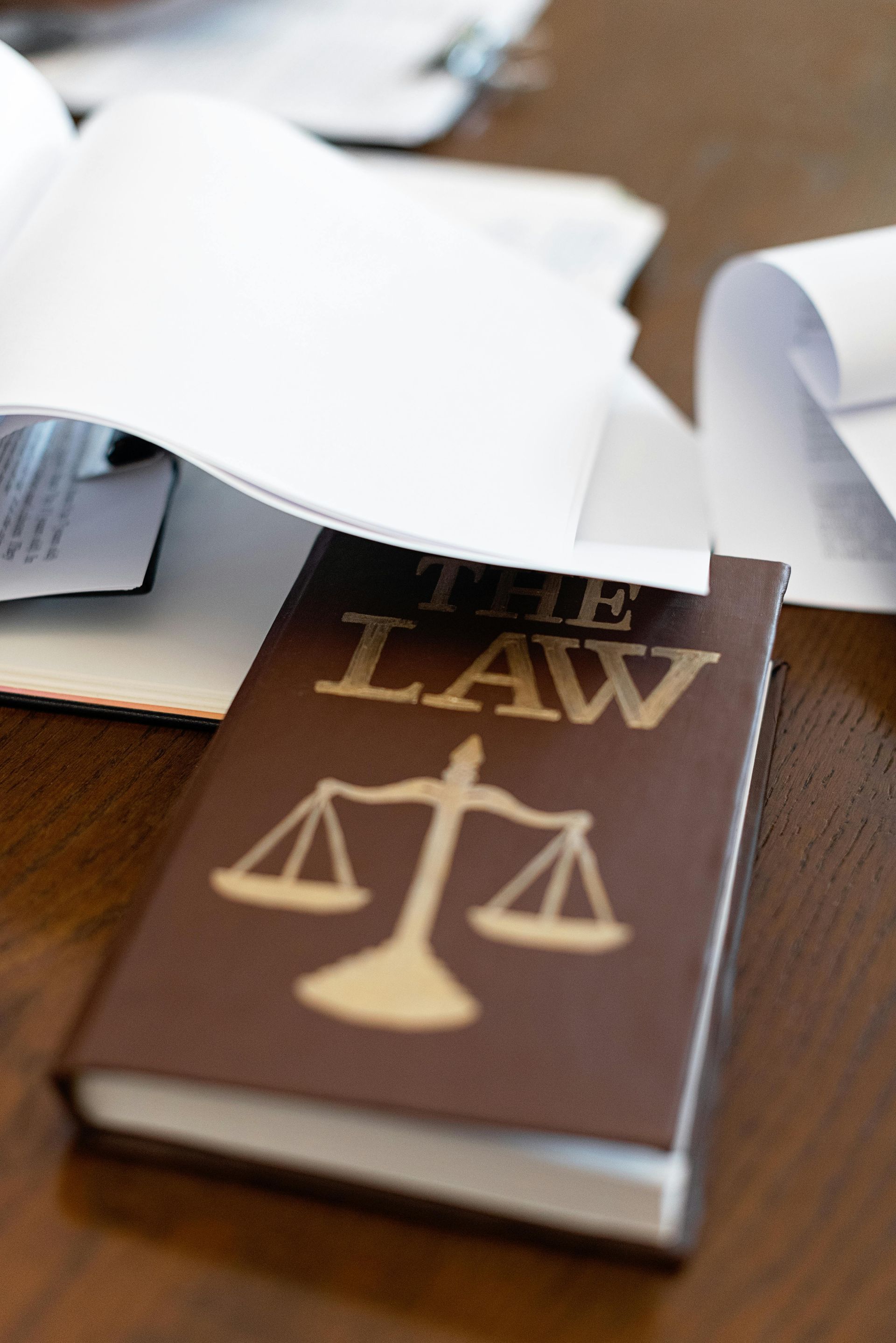 A book titled the law sits on a wooden table