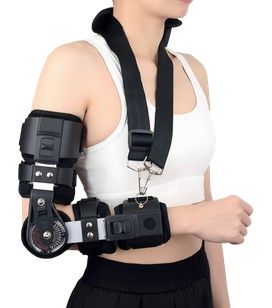 Persona que lleva un soporte de brazo y hombrera negros sobre una blusa blanca.