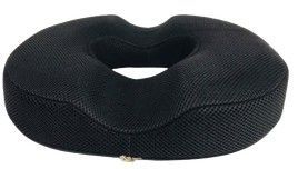 Cojín negro con forma de rosquilla y centro hueco sobre fondo blanco.
