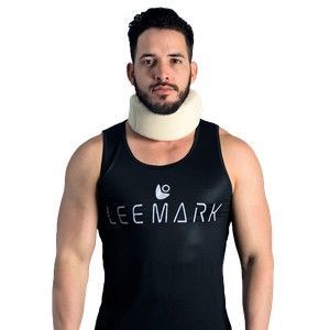 Hombre con camiseta negra sin mangas y collarín blanco, de pie sobre un fondo blanco.
