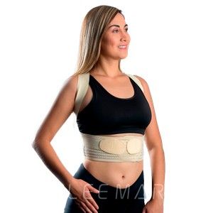 Mujer con faja lumbar beige sobre sujetador deportivo y pantalones cortos negros, de perfil sobre fondo blanco.