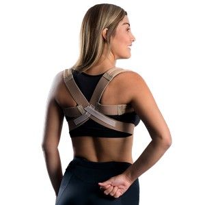 Mujer con un corrector postural negro y beige, vista de espaldas sobre un fondo blanco.
